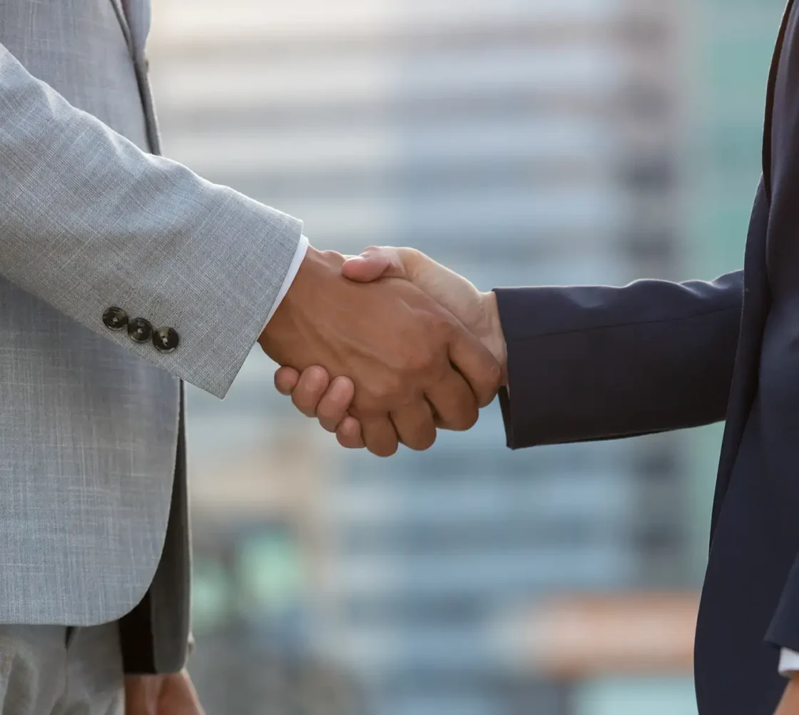 businesspeople standing city street shaking hand crops
